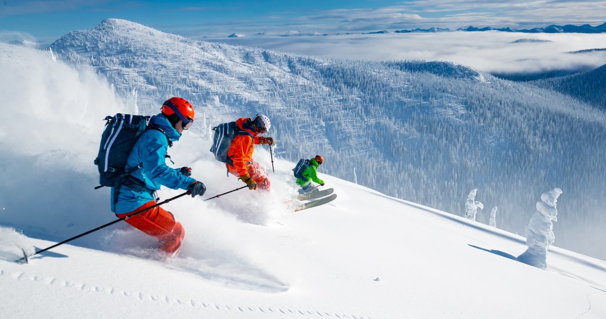 Skiers carving deep powder on alpine mountain powder slope