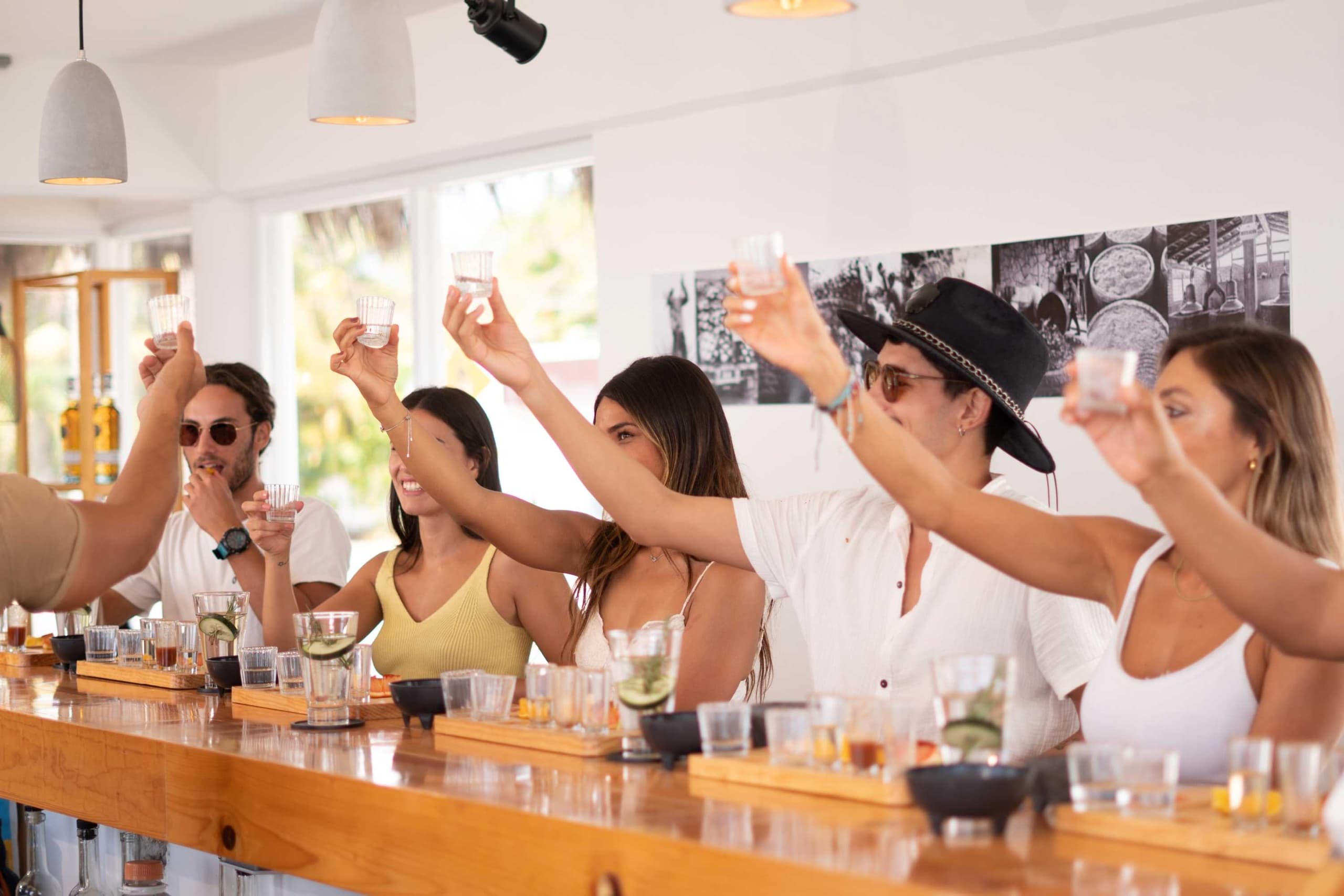 Group tasting spirits at indoor cocktail bar, not outdoor activity