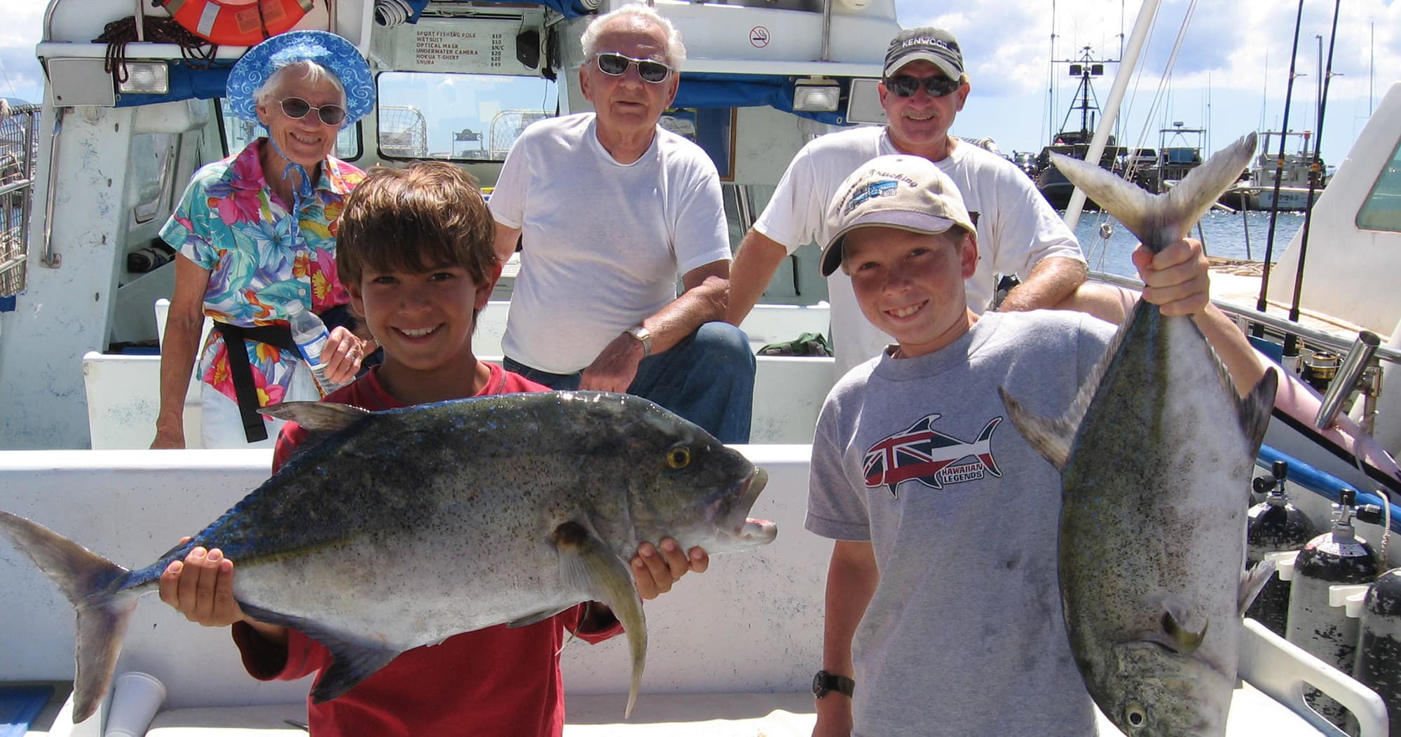 Happy anglers posing with giant reef fish aboard fishing charter