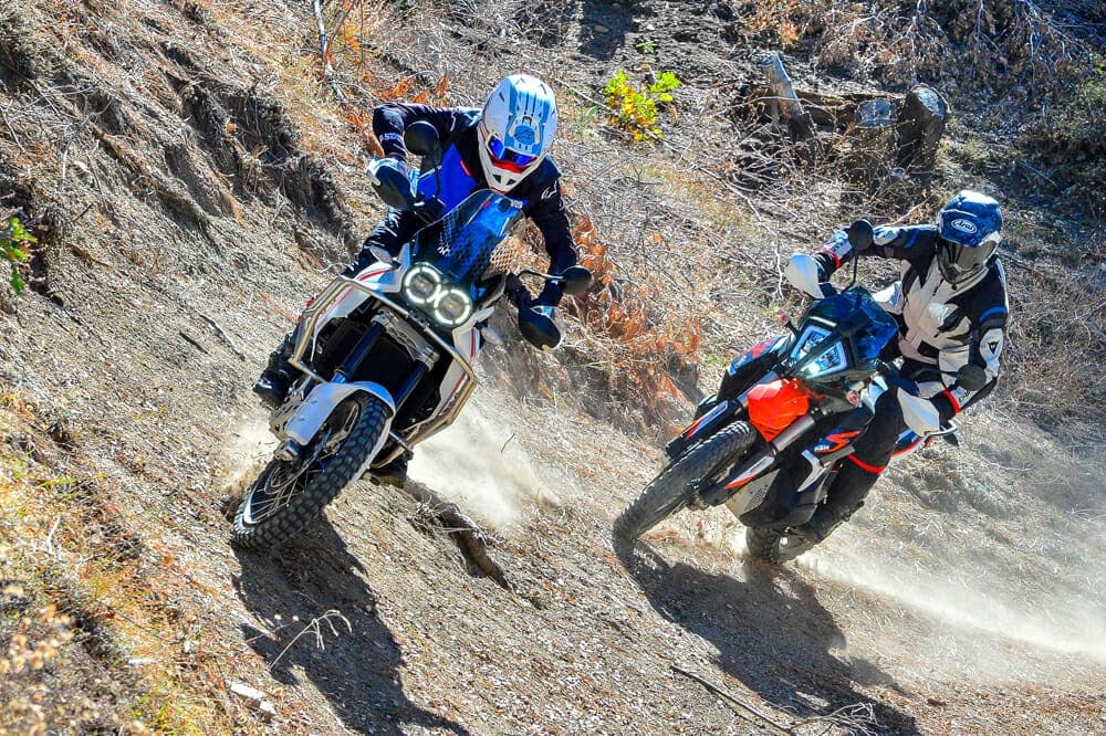 Dual-sport riders charging a dusty Mojave desert off-road trail