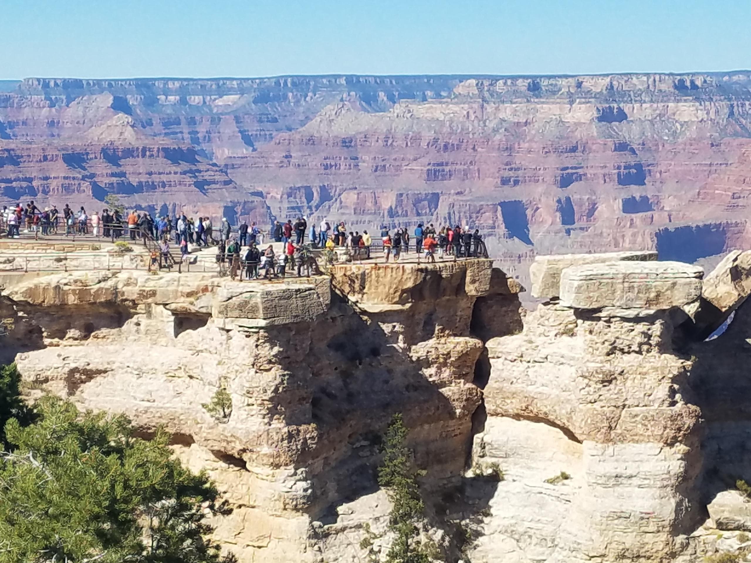 Grand Canyon overlook with visitors on rocky rim and vast vista