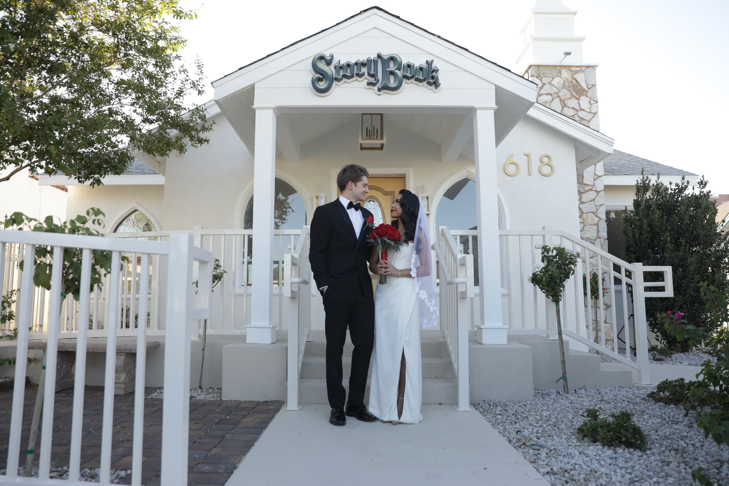 Newlyweds kissing outside Storybook wedding chapel entrance in daylight