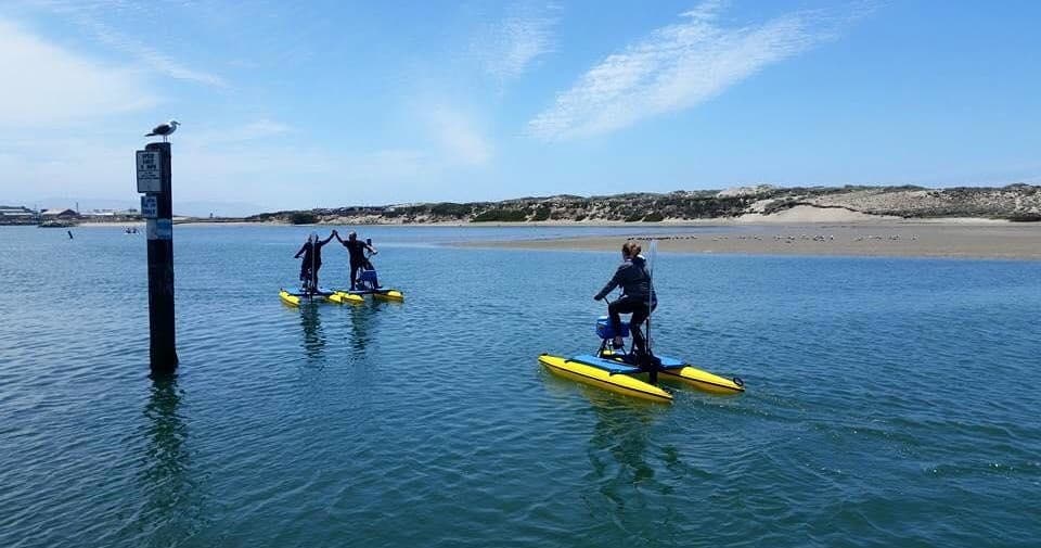 Group hydrobikers riding near sandy Monterey Bay shoreline