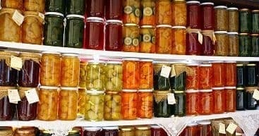 Assorted preserved jams and pickles displayed on market shelves