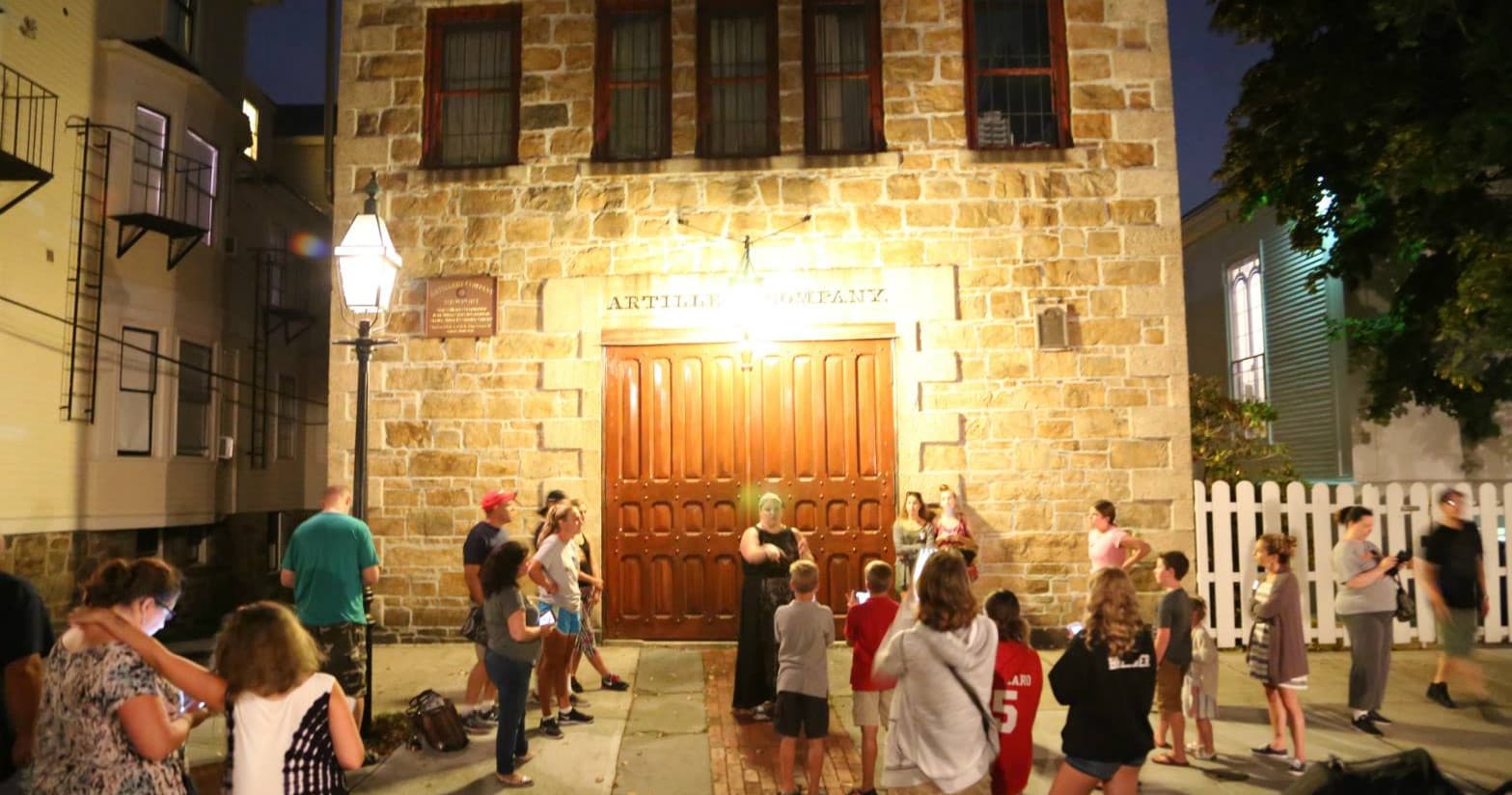 Night ghost walking tour outside historic Newport stone building