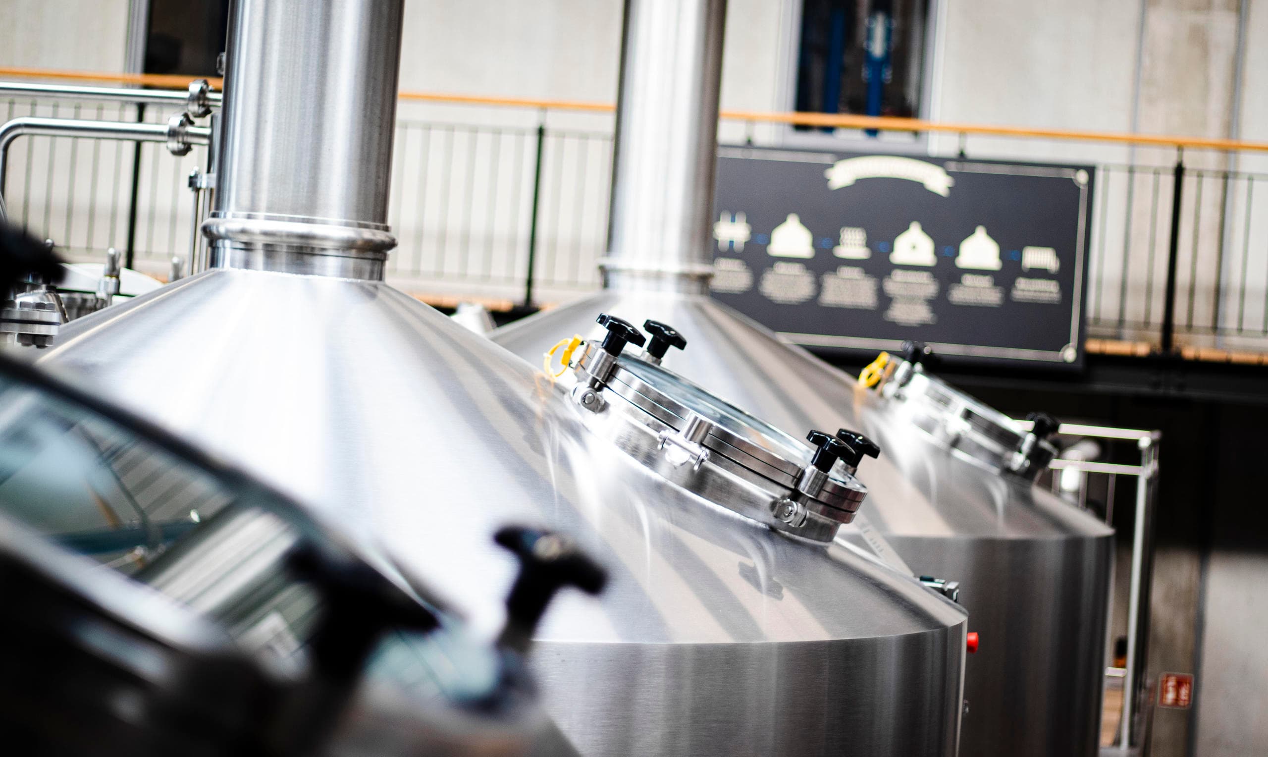 Close-up stainless brew tanks in production hall, detailed