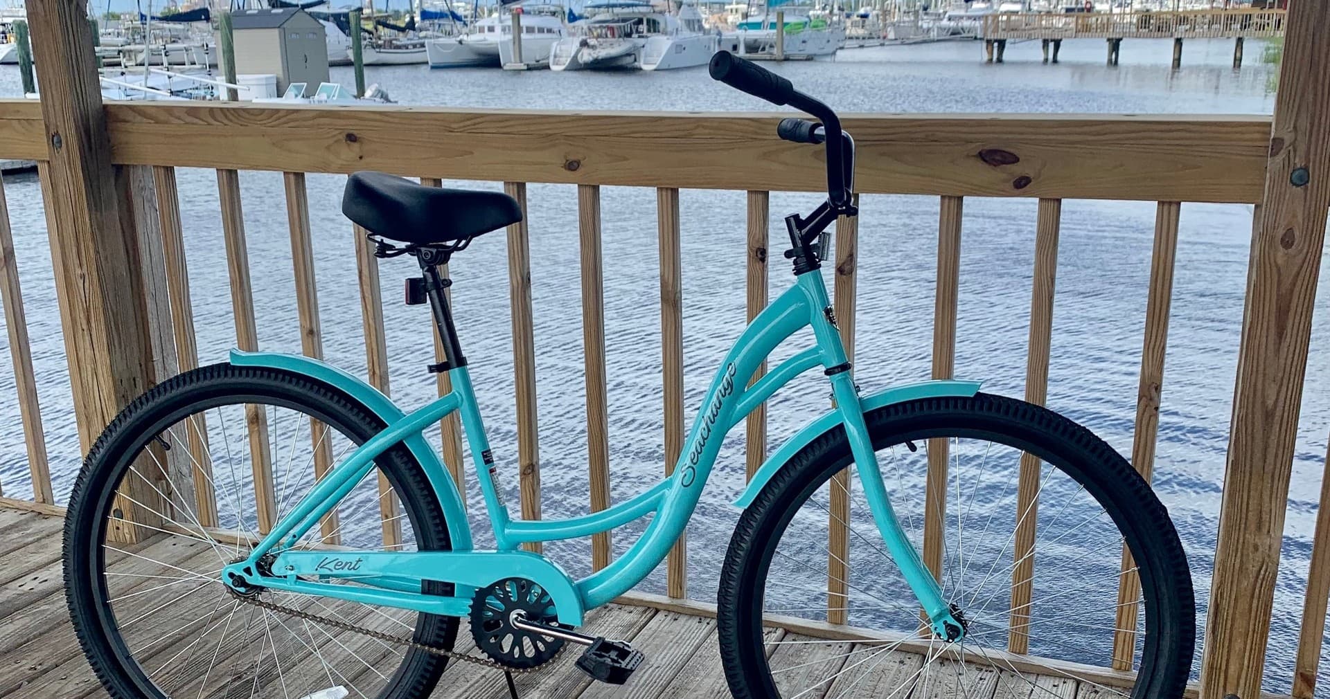 Turquoise cruiser bike parked on waterfront marina