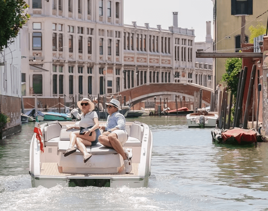 Couple relaxing on deck of boat cruising Venice canals