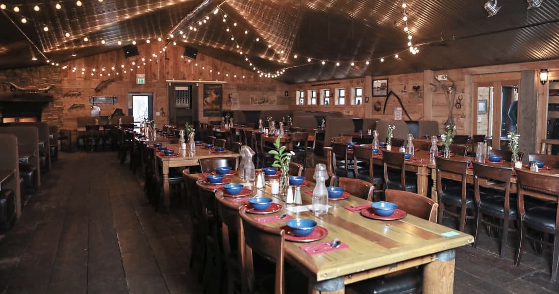 Cozy rustic dining room with long tables and string lights