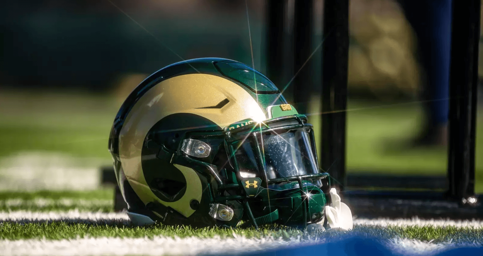 Football helmet on turf sidelines at outdoor stadium scene