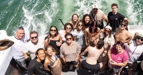 Charter boat group enjoying wake and sun on Raglan coastal cruise