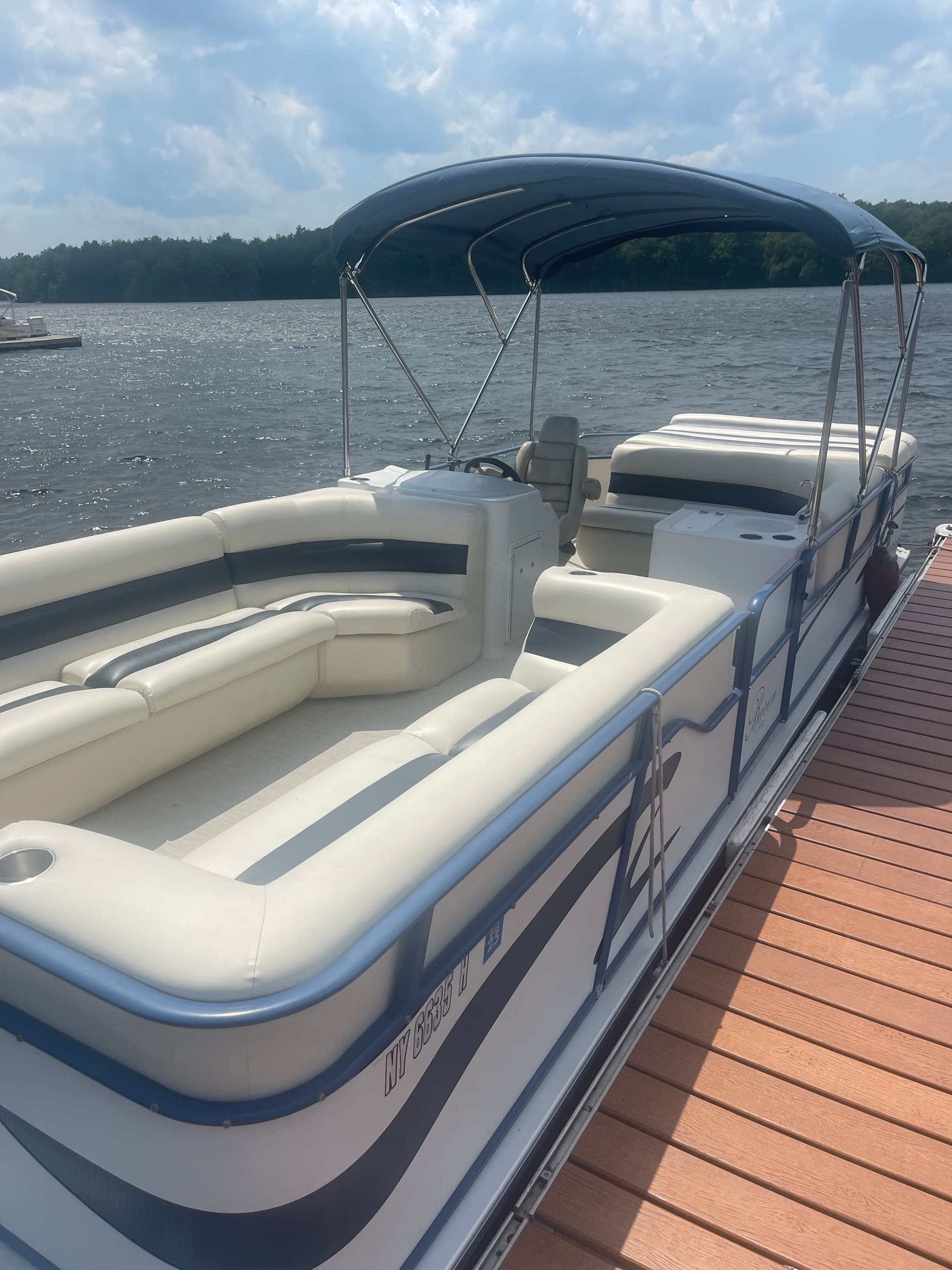 Spacious pontoon boat seating and helm view docked on lake