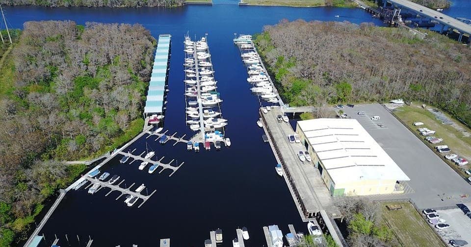 Marina aerial with docks and river channel through coastal wetlands