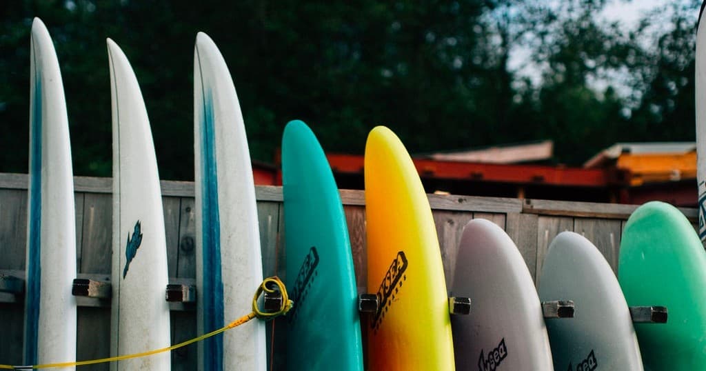 Colorful surfboards lined up at coastal rental shack, ready