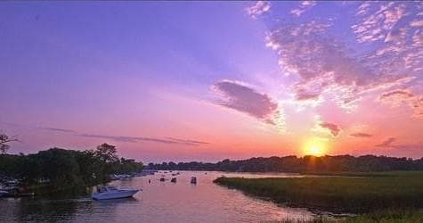 Sunset over tranquil bay with boats anchored, scenic view