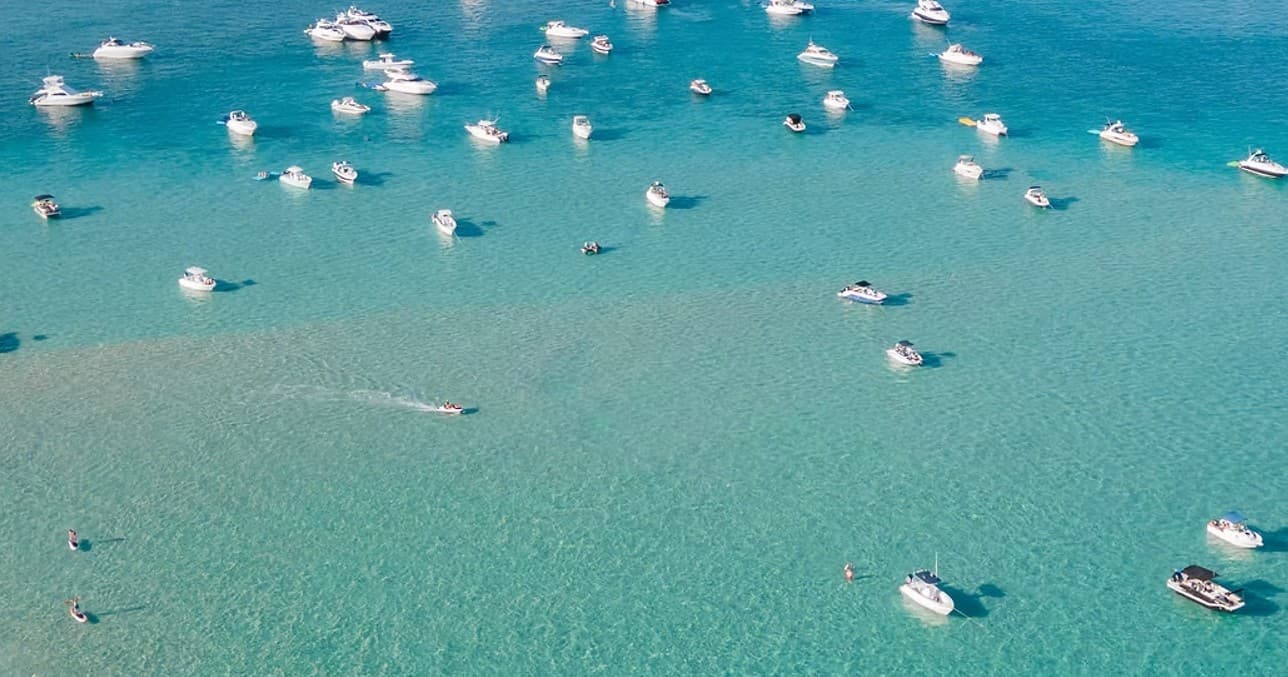 Aerial view of boats anchored in turquoise coastal bay