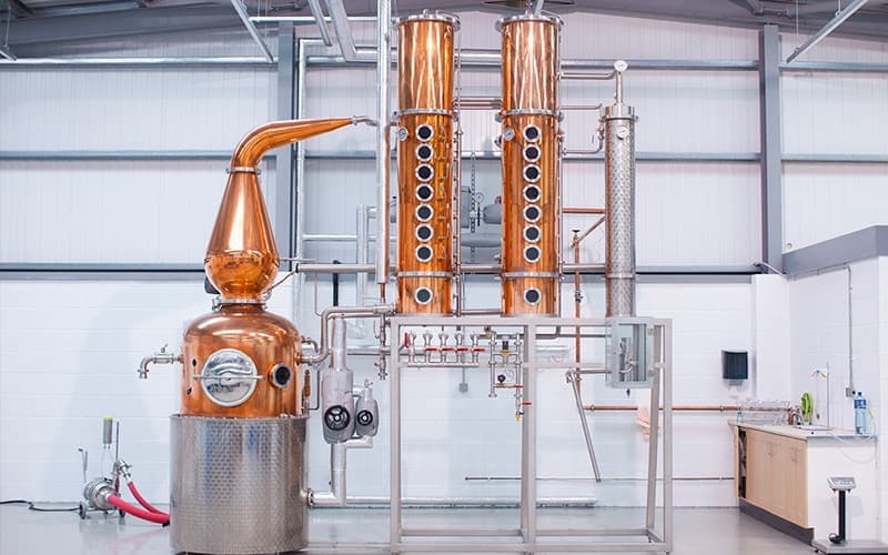 Modern copper column still setup in bright industrial distillery
