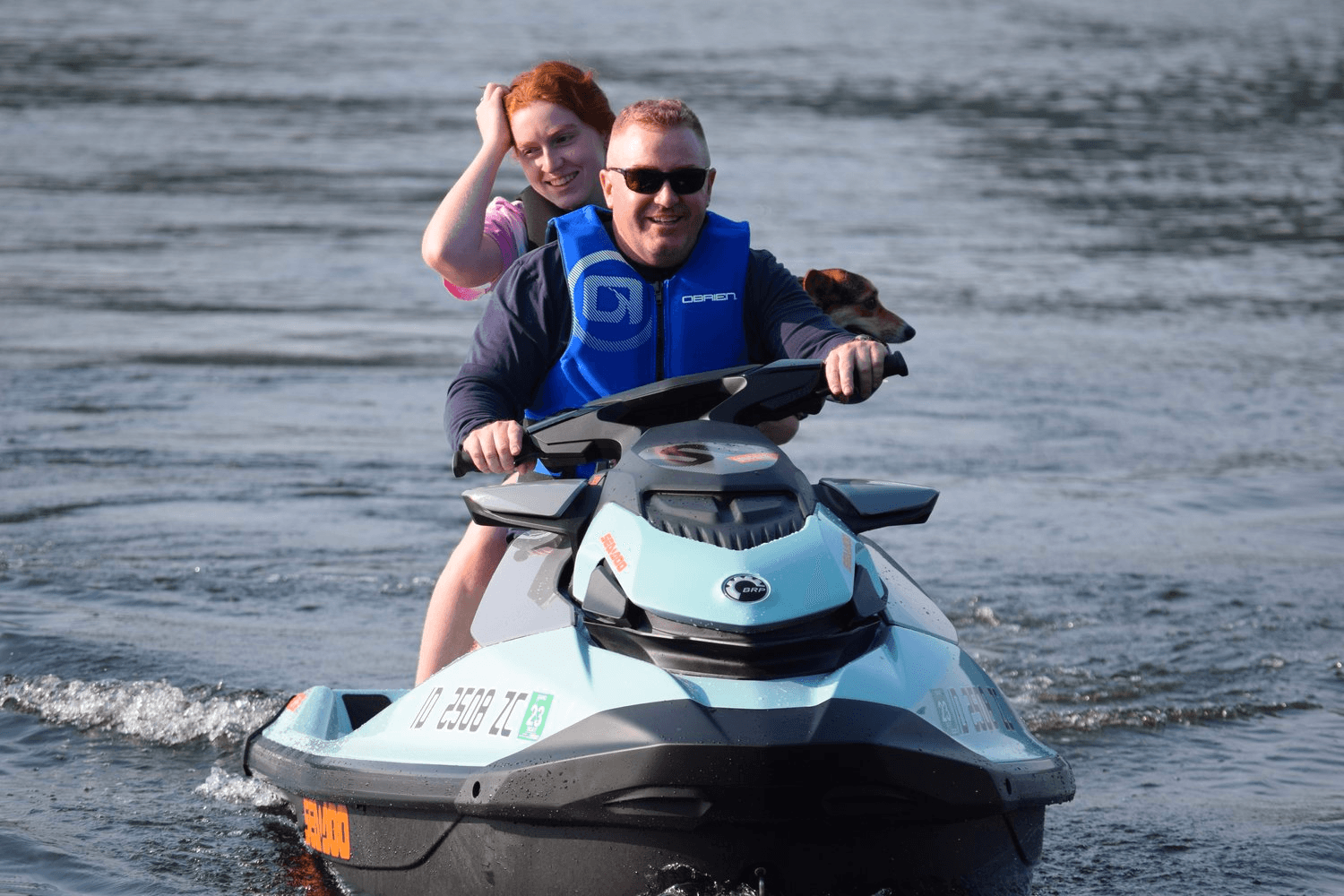 Two people riding personal watercraft on calm lake waters