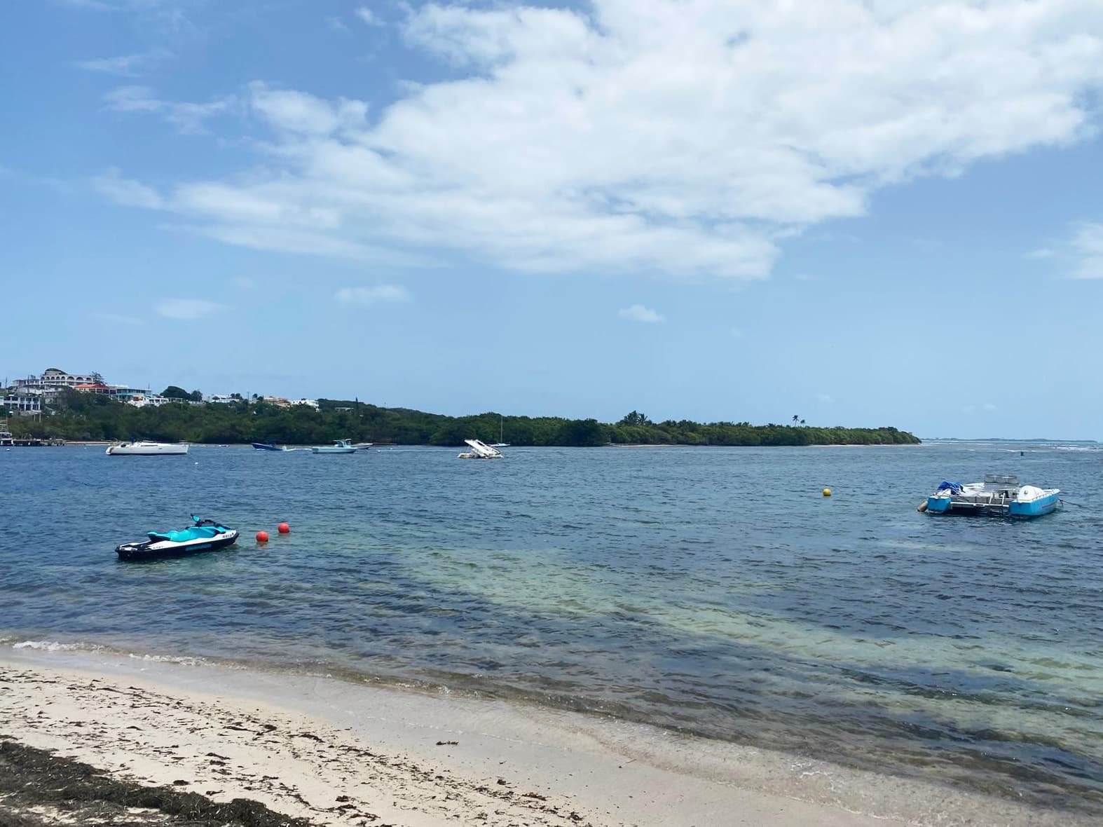 Calm shoreline with small boats anchored off sandy Puerto Rico beach