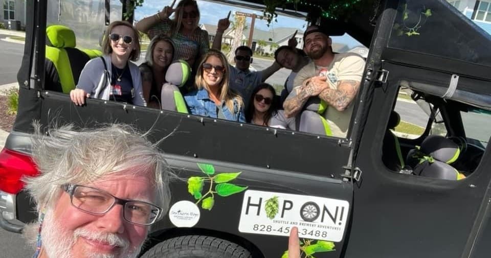 Smiling riders inside open-air tour vehicle on city street