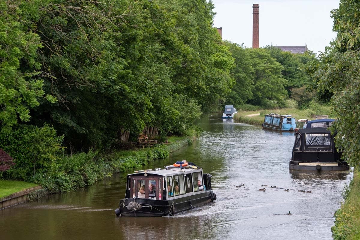 Narrowboat cruising a tree-lined Lancashire canal, serene cruise