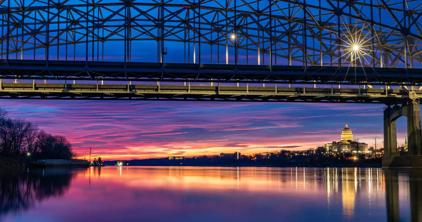 Sunset river and bridge with capitol skyline reflection