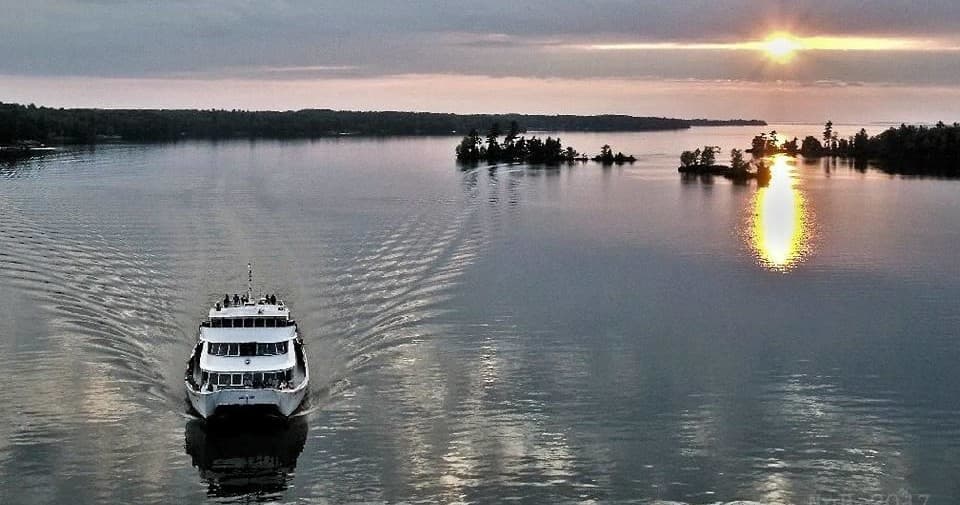 Aerial view of tour boat cutting through calm reflective waters
