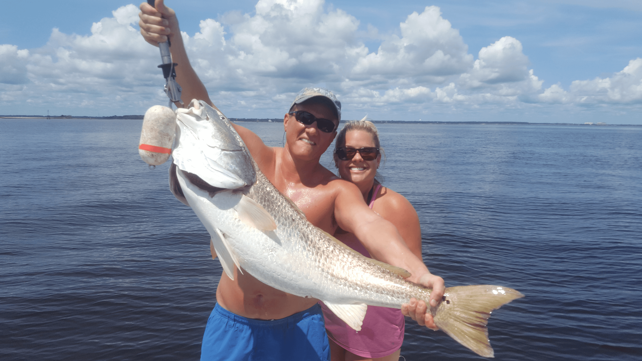 Couple holding large redfish on open Atlantic near Amelia Island
