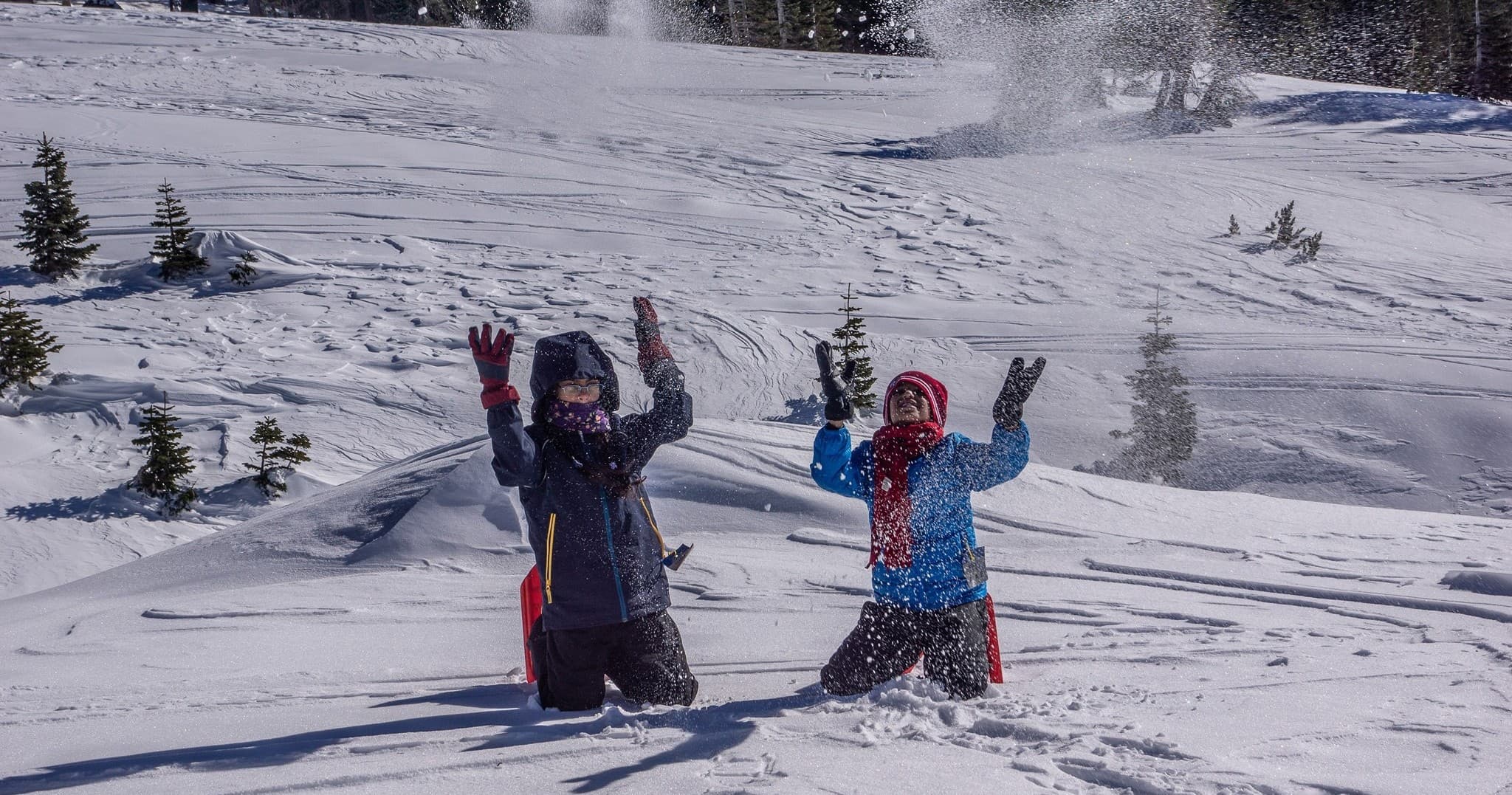 Friends playing in deep snow on mountain slope, winter adventure