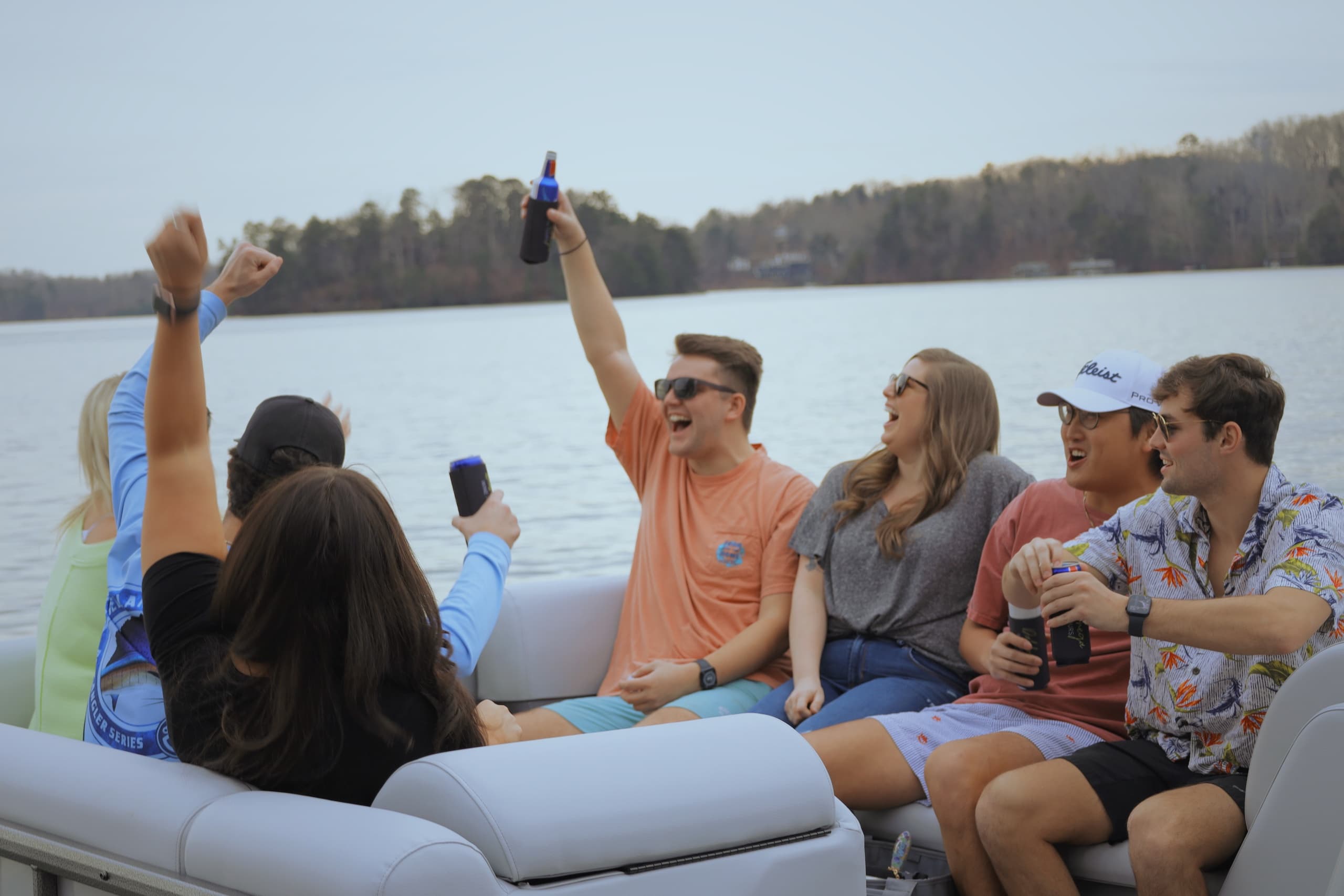 Group on pontoon boat cruising Lake Lanier, friends cheering
