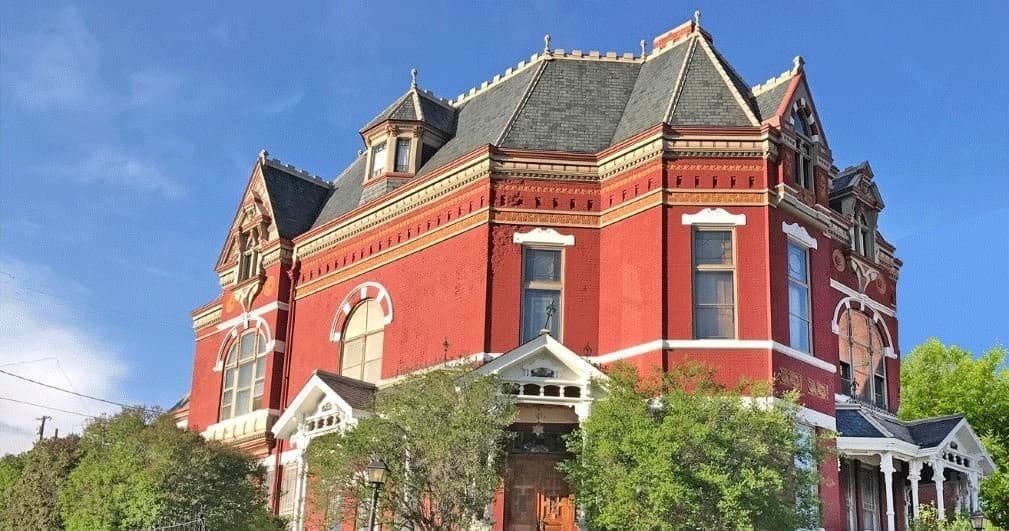 Historic Victorian mansion exterior in sunny small-town sightseeing