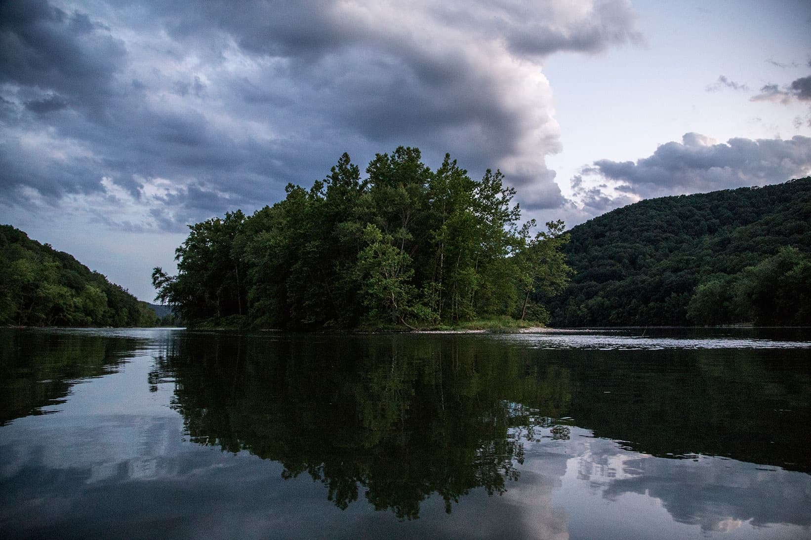 Twin-island reflection at dusk on tranquil river lake vista