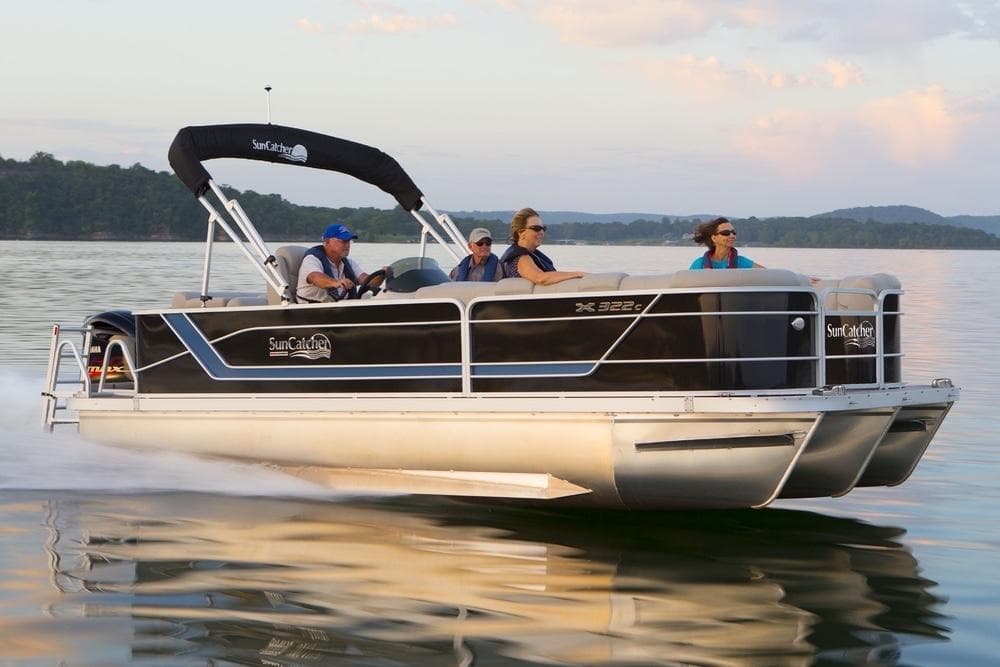 Pontoon boat sunset cruise on calm lake with passengers relaxing