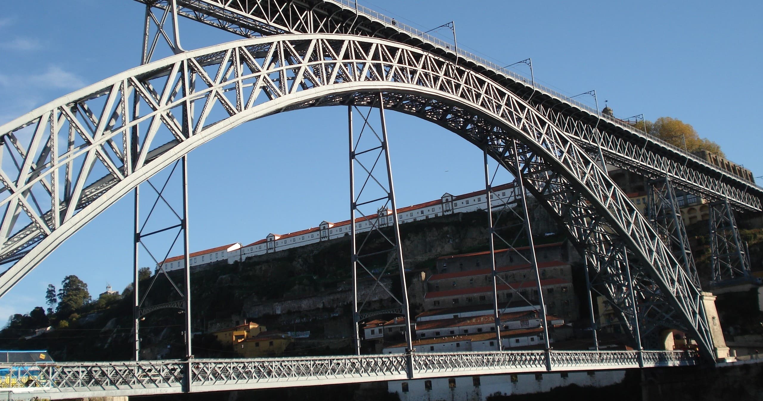 Dramatic steel arch bridge spanning river in cityscape