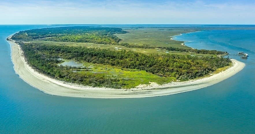 Aerial view of crescent barrier island with sandy beaches