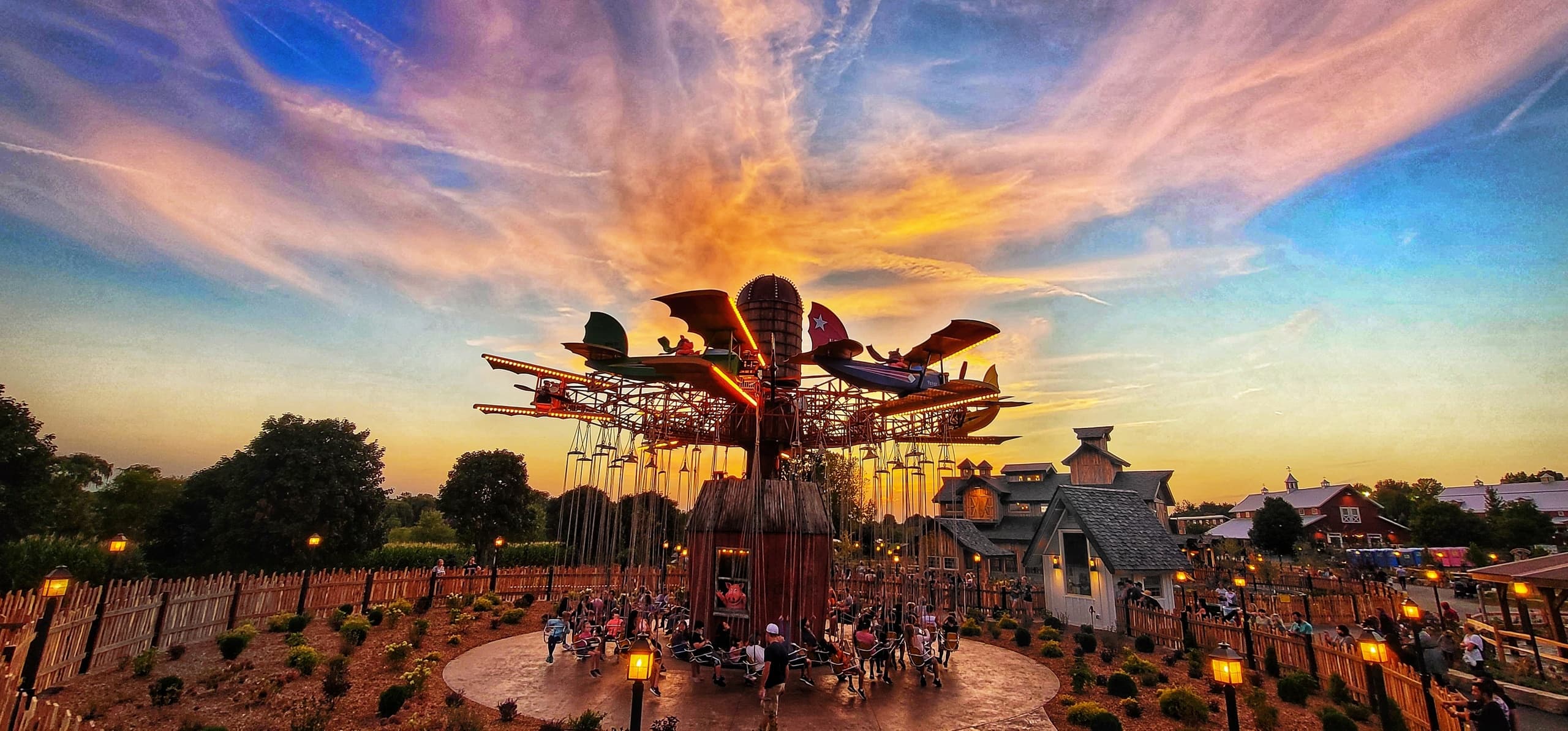 Swing-carousel ride at pumpkin farm festival at sunset