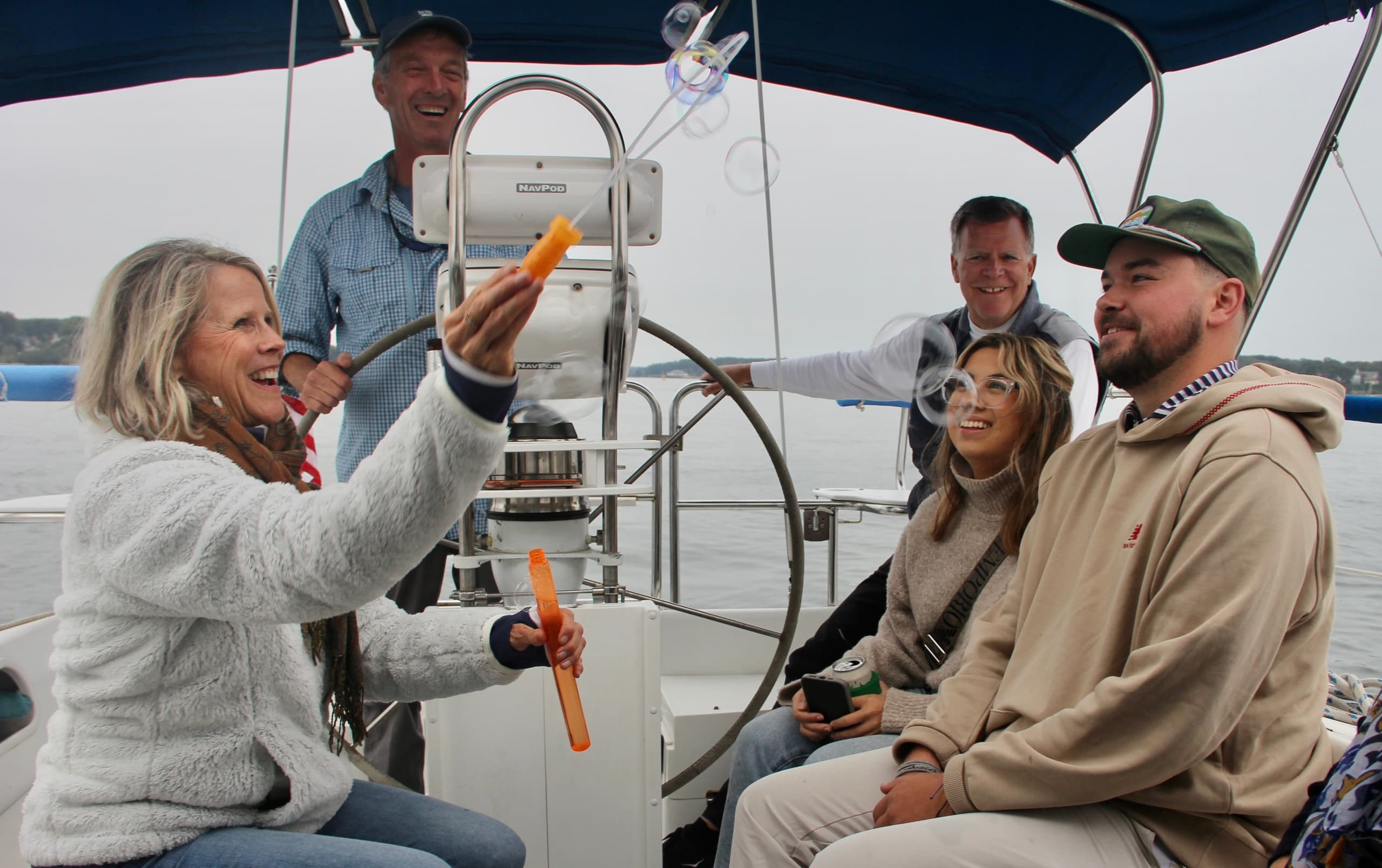 Passengers laughing on sailboat deck during daytime cruise
