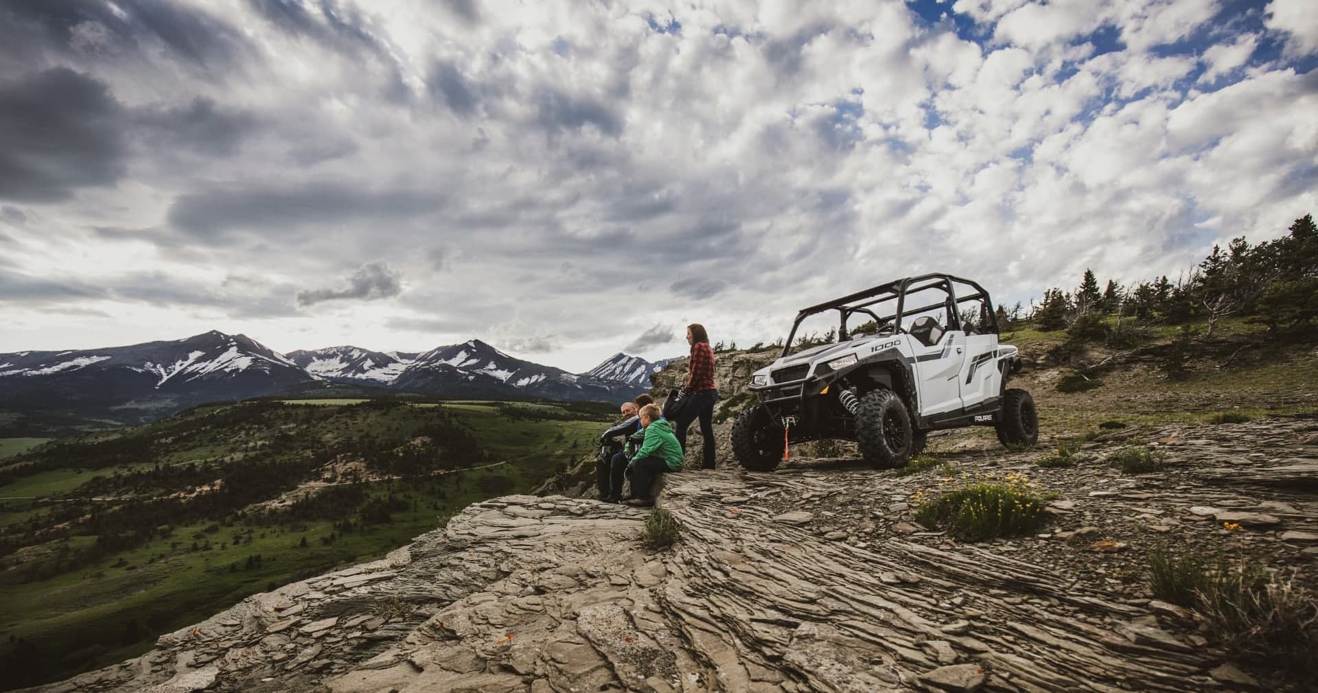 Off-road UTV parked on rocky overlook with mountain view