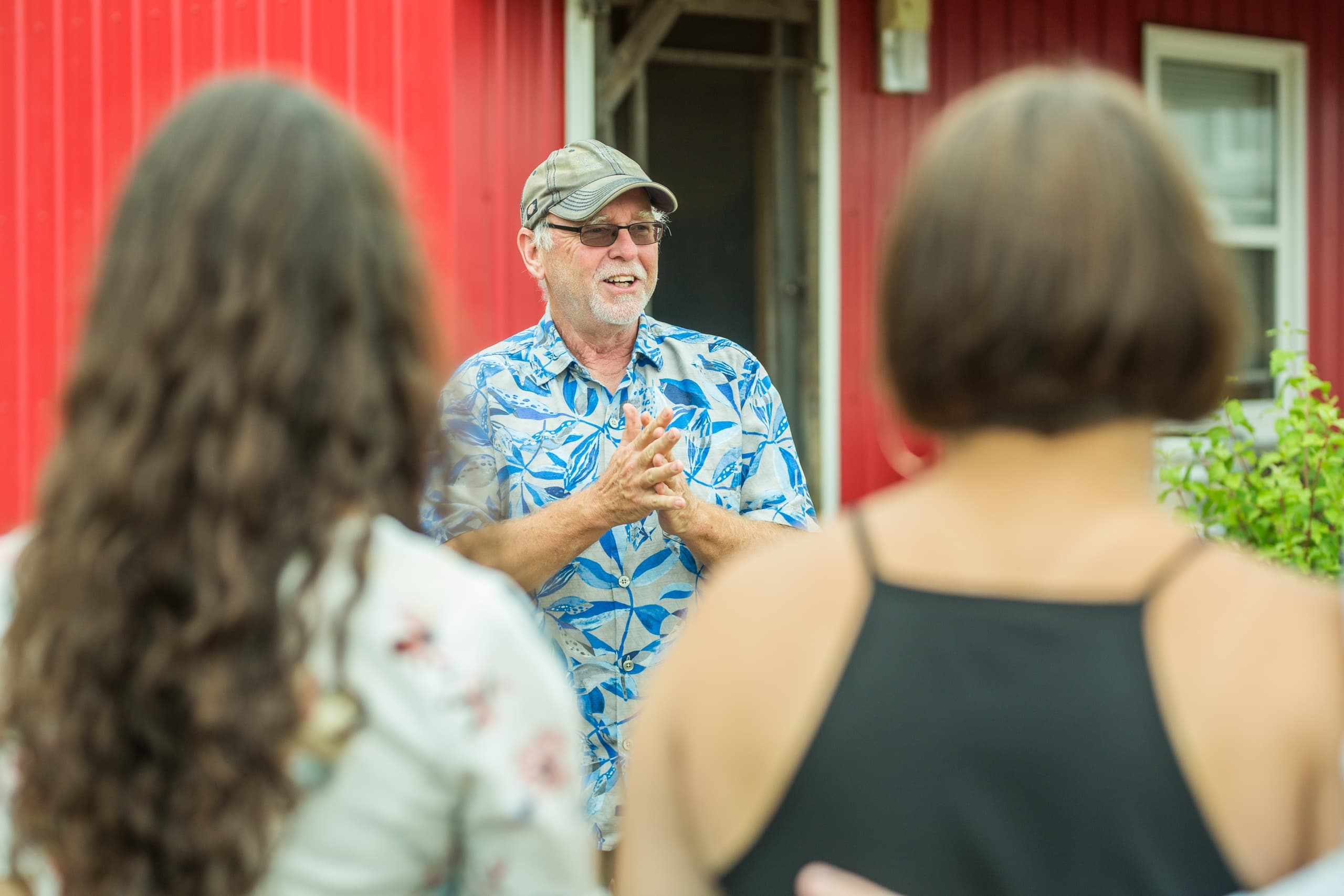 Wine tasting tour guide briefing group outside red barn