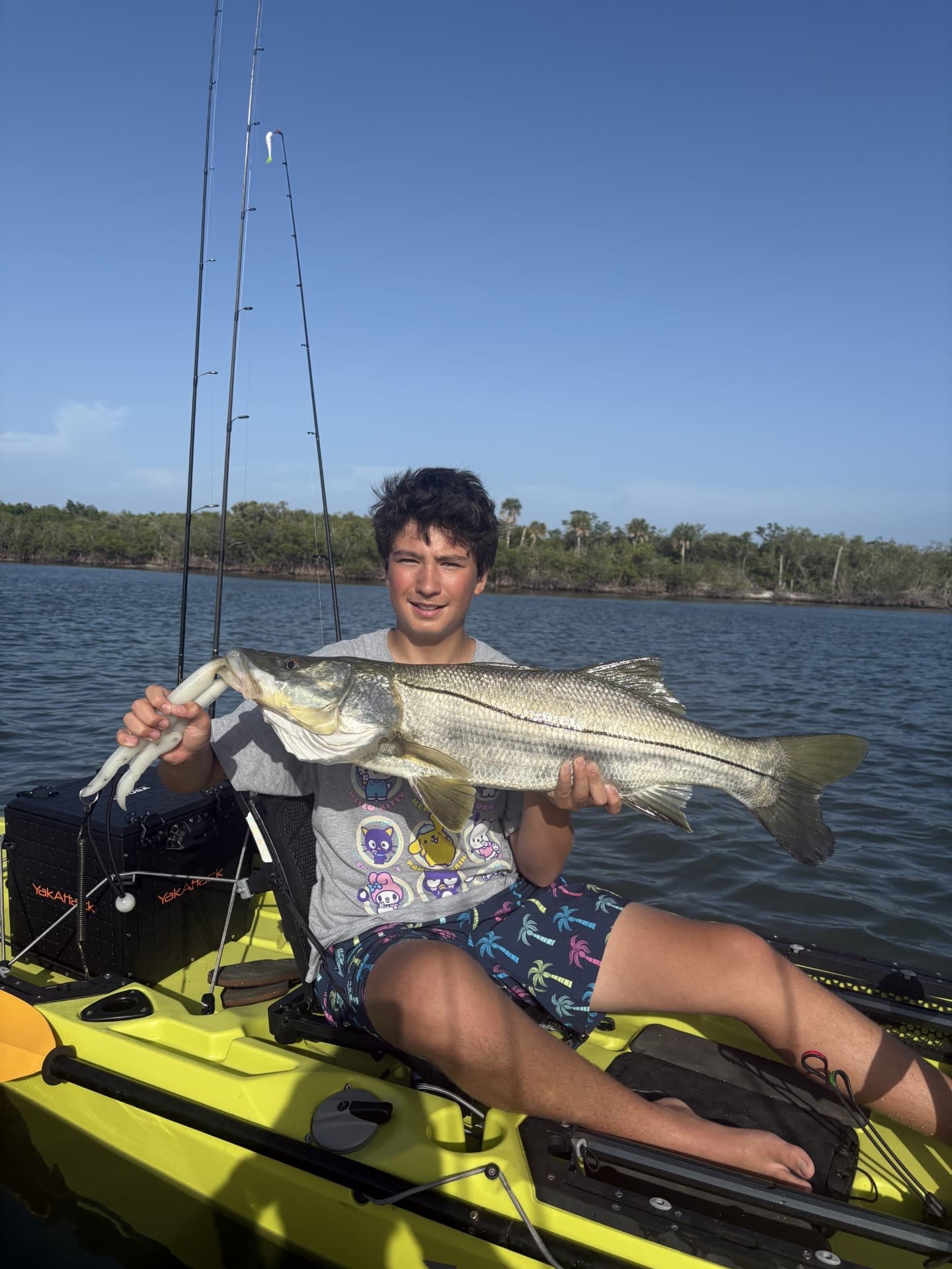 Young angler posing with snook on a kayak in backwater
