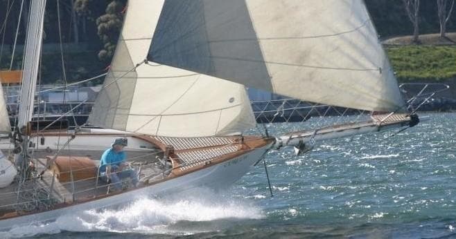 Classic sailboat heeling through choppy water in race