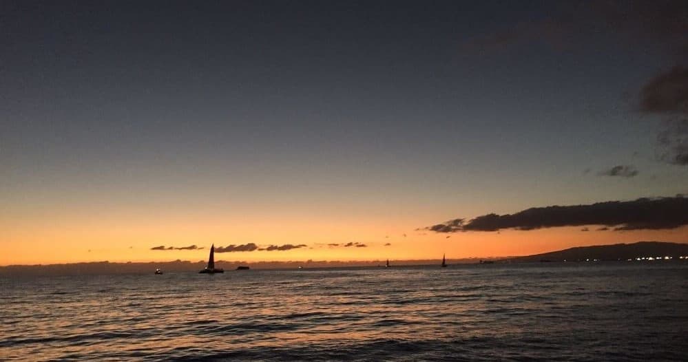 Ocean sunset over Waikiki with sailboats on calm sea