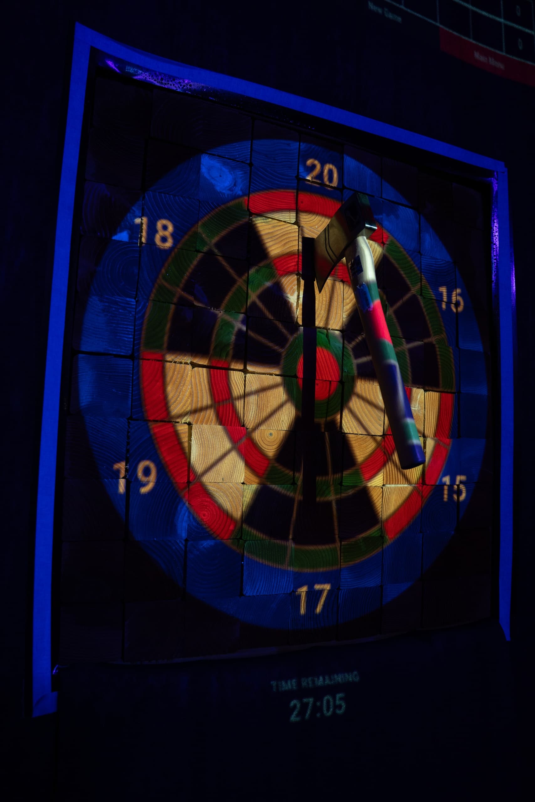 Vertical illuminated dartboard target with digital score display indoors