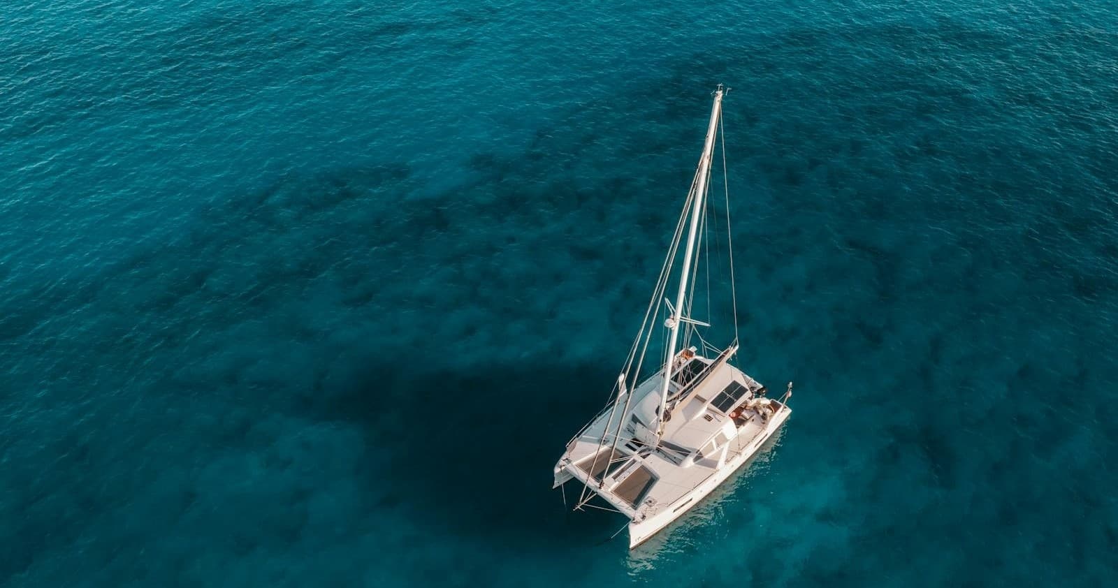 Aerial sailboat cruising turquoise open ocean, tranquil sailing