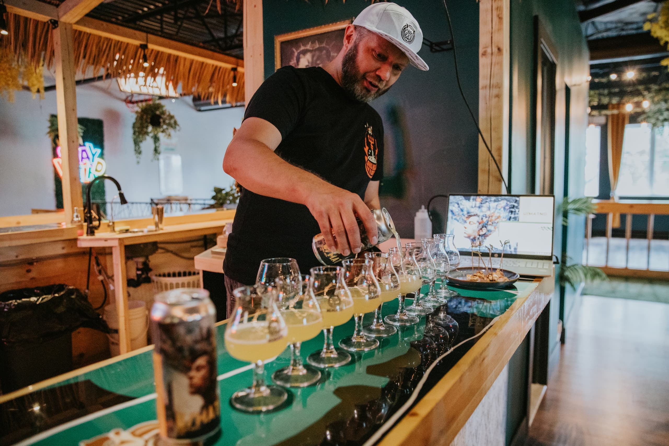 Bartender pouring craft beers across tasting flight at brewery
