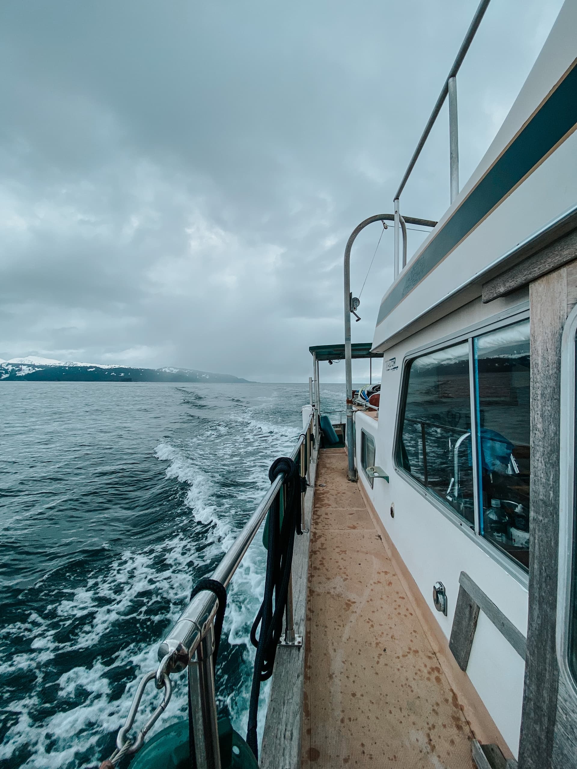 Passengers on Alaska boat deck cruising coastal waters and glaciers