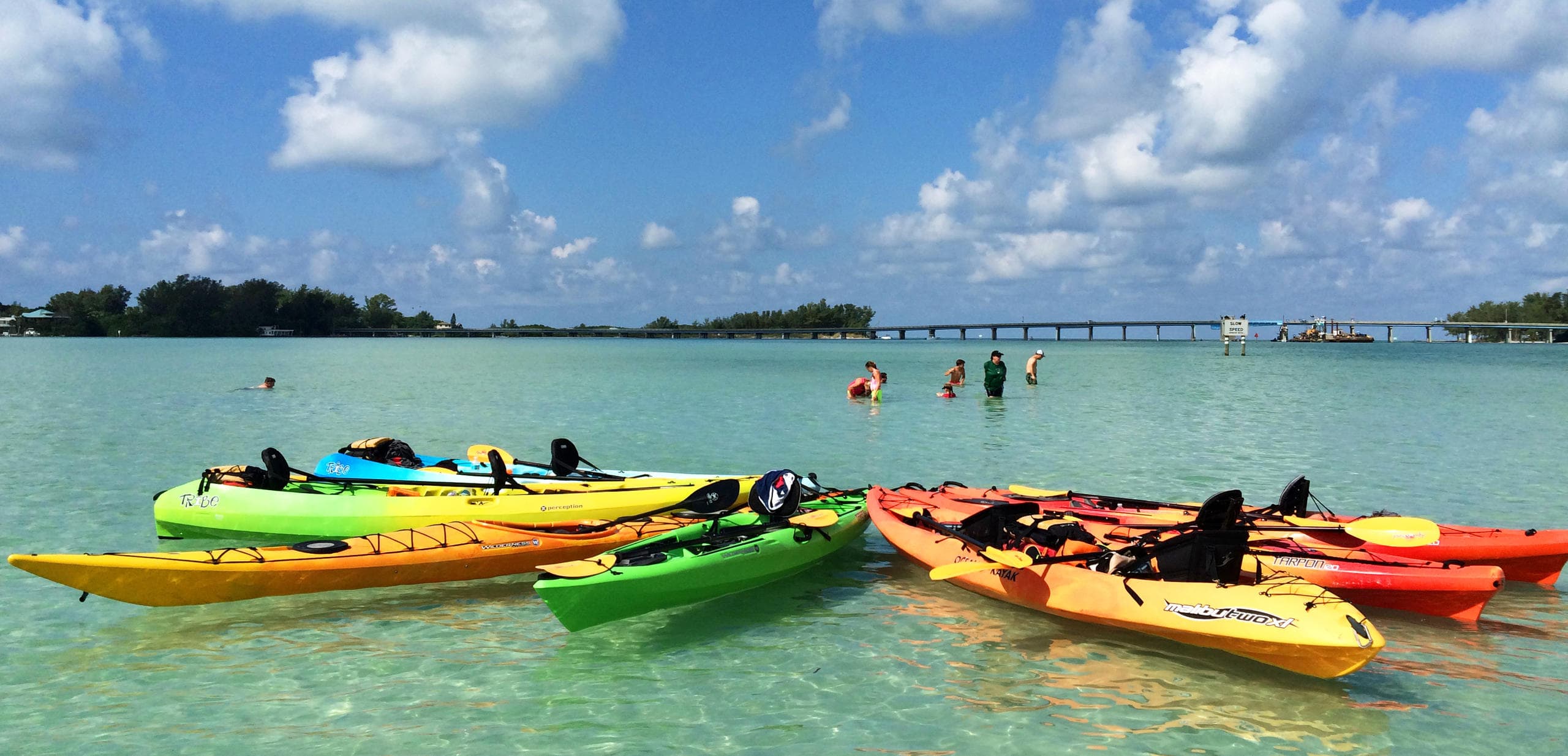 Colorful kayaks floating in clear tropical bay under blue sky