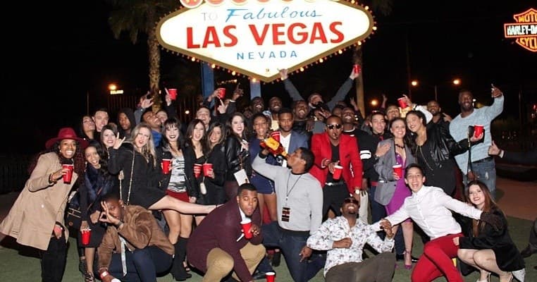 Tour group posing at Las Vegas Welcome sign on night tour