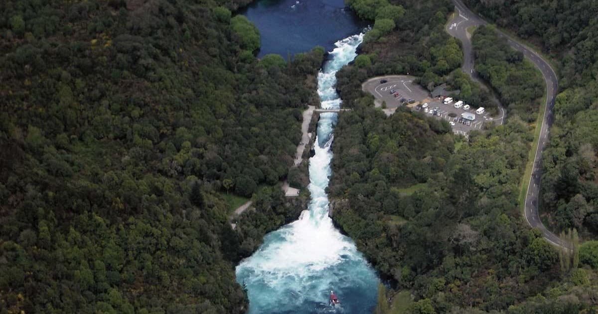 Aerial waterfall plunging through forested gorge, scenic vista