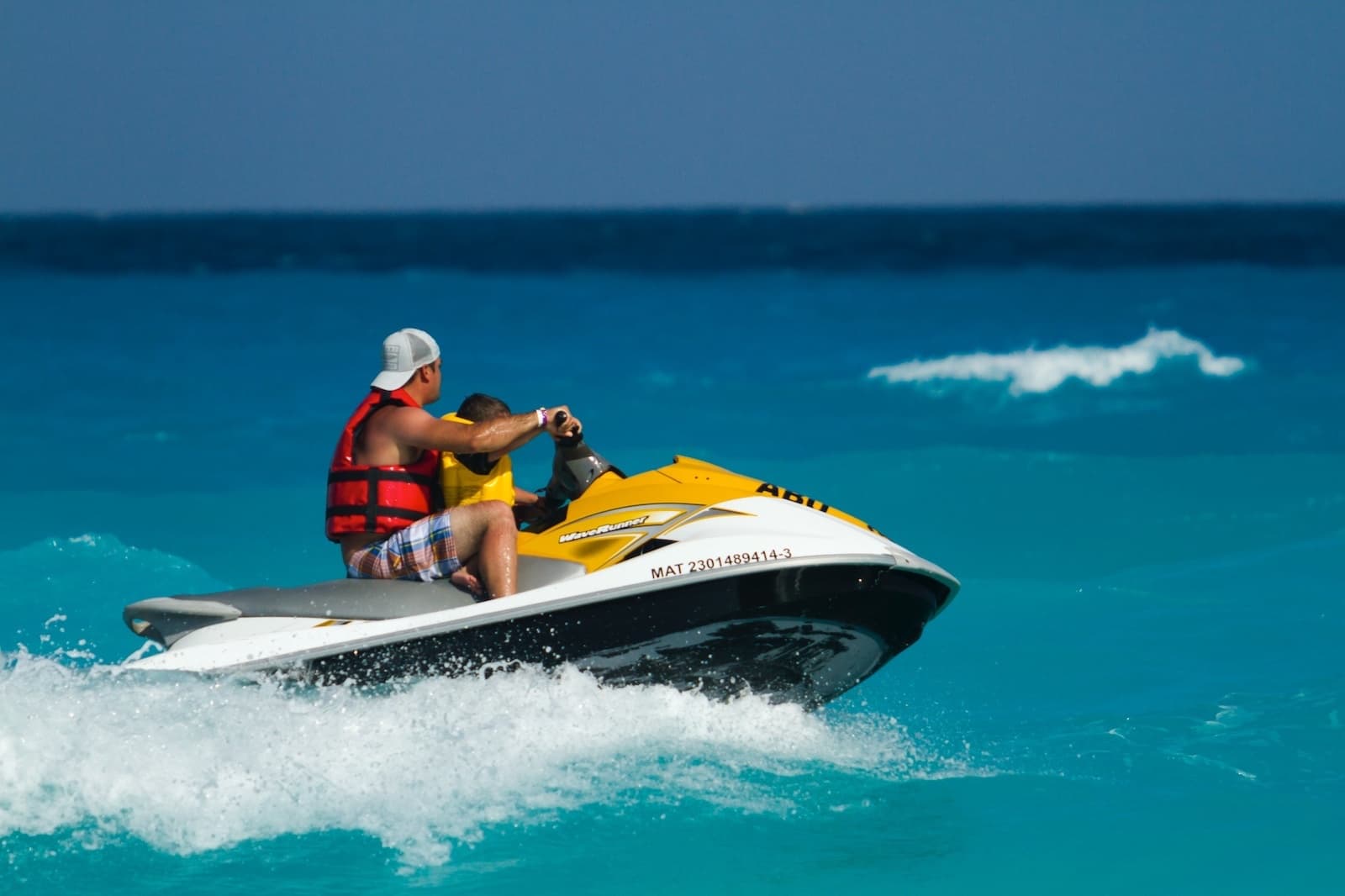 Jet ski riders speeding over bright turquoise ocean, adrenaline tour